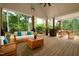 Inviting back porch with wood floors, comfortable seating, and a view of lush greenery at 690 Oaks Lane Rd, Timberlake, NC 27583