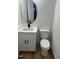 Elegant bathroom with a modern vanity, round mirror, and a toilet, showcasing stylish fixtures at 690 Oaks Lane Rd, Timberlake, NC 27583