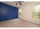 Bedroom with accent wall, neutral carpet, a modern ceiling fan, and two windows with verdant views at 690 Oaks Lane Rd, Timberlake, NC 27583