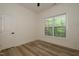 Bright bedroom with hardwood flooring, a ceiling fan, and a window overlooking trees and a porch at 690 Oaks Lane Rd, Timberlake, NC 27583