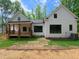 Charming exterior showcasing a modern farmhouse with a well-manicured lawn and a covered back porch at 690 Oaks Lane Rd, Timberlake, NC 27583