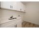 Bright laundry room with white cabinetry, stainless steel sink, and modern quartz countertop at 690 Oaks Lane Rd, Timberlake, NC 27583
