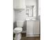 This quaint bathroom features a vanity, toilet, mirror, and wood look floors at 7924 Knightdale Blvd, Knightdale, NC 27545