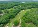 Aerial view of the golf course winding through the neighborhood with wooded tree coverage at 8011 Old Trail Dr, Durham, NC 27712