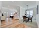 Open-concept dining area featuring hardwood floors and a modern light fixture at 8011 Old Trail Dr, Durham, NC 27712