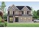 Elegant two-story home with a brick facade, black shutters, and a well-manicured lawn at 8011 Old Trail Dr, Durham, NC 27712