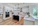Modern kitchen with white cabinetry, a center island, stainless steel appliances, and hardwood floors at 8011 Old Trail Dr, Durham, NC 27712