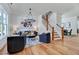 Bright living room features hardwood floors, a modern chandelier, and staircase with wooden railing at 8011 Old Trail Dr, Durham, NC 27712