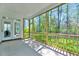 Relaxing screened porch with wood railing offers serene view of lush greenery at 8011 Old Trail Dr, Durham, NC 27712