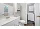 Bright bathroom with white cabinets, basket storage, and a convenient adjacent laundry area at 100 Honeysuckle Ln, Cary, NC 27513