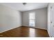 Cozy bedroom with natural light from a window and gleaming hardwood floors at 100 Honeysuckle Ln, Cary, NC 27513