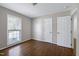 Bedroom with neutral walls, gleaming hardwood floors, and white doors at 100 Honeysuckle Ln, Cary, NC 27513