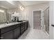 Bathroom with double vanity, granite countertops, tiled floors, and glass-door shower at 100 Pronghorn Deer Ct, Garner, NC 27529