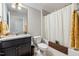 Well-lit bathroom with granite countertop vanity, toilet, and bathtub with shower at 100 Pronghorn Deer Ct, Garner, NC 27529