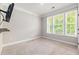 Bright bedroom with large windows, neutral carpet, and a mounted TV at 100 Pronghorn Deer Ct, Garner, NC 27529
