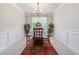 Formal dining room featuring wainscoting, a stylish chandelier, and a dining table set for a meal at 100 Pronghorn Deer Ct, Garner, NC 27529