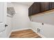 Functional laundry room featuring wood-look flooring, dark cabinetry, and washer/dryer hookups at 100 Pronghorn Deer Ct, Garner, NC 27529