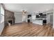 Open-concept living area with stone fireplace, hardwood floors, and an eat-in kitchen island at 100 Pronghorn Deer Ct, Garner, NC 27529