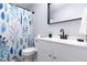 The bathroom has a leafy shower curtain, a white sink and vanity, and a mirror at 1002 Willow Dr # Apt 107, Chapel Hill, NC 27514