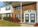 Two-story brick townhome exterior with black shutters and manicured lawn at 1002 Willow Dr # Apt 107, Chapel Hill, NC 27514