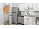 Well-lit kitchen with stainless steel refrigerator, subway tile backsplash, and laundry area at 1002 Willow Dr # Apt 107, Chapel Hill, NC 27514