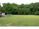 Spacious backyard featuring green grass, mature trees, and a trampoline at 1008 Catsby Cir, Raleigh, NC 27603