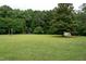 Expansive backyard featuring mature trees, green grass, and plenty of space for outdoor activities at 1008 Catsby Cir, Raleigh, NC 27603