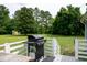 Backyard featuring a grill on a deck with a white fence and mature trees at 1008 Catsby Cir, Raleigh, NC 27603