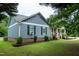 Charming home featuring blue siding, white trim, and a landscaped front yard with mature trees at 1008 Catsby Cir, Raleigh, NC 27603