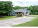 Inviting curb appeal of a cozy home featuring a long driveway and large yard with mature trees at 1008 Catsby Cir, Raleigh, NC 27603