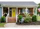 Cozy front porch with a chair, colorful door, and charming details at 1008 Catsby Cir, Raleigh, NC 27603