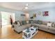 Bright living room featuring light hardwood floors, a ceiling fan, and a comfortable sectional sofa at 1008 Catsby Cir, Raleigh, NC 27603