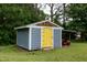 View of backyard outbuilding with light blue siding, a yellow door and a mower at 1008 Catsby Cir, Raleigh, NC 27603