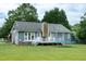 View of the back of the house with a deck, backyard, and mature trees at 1008 Catsby Cir, Raleigh, NC 27603