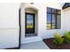 Elegant home entrance featuring a paneled front door, white brick facade, and modern black trim at 1012 Lily Claire Ln, Fuquay Varina, NC 27526