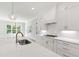 Bright kitchen featuring a sink and stovetop on an island with white countertop at 1012 Lily Claire Ln, Fuquay Varina, NC 27526