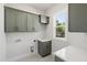 Well-equipped laundry room boasts custom cabinets, counter space, and natural light at 1012 Lily Claire Ln, Fuquay Varina, NC 27526