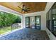 Covered patio with ceiling fan, stone flooring, and sliding glass doors to the interior at 1012 Lily Claire Ln, Fuquay Varina, NC 27526