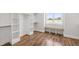 Walk-in closet with custom shelving, wooden floors, and a window with a bench at 1012 Lily Claire Ln, Fuquay Varina, NC 27526