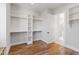 Spacious walk-in closet with custom shelving, hardwood floors, and an adjoining bathroom at 1012 Lily Claire Ln, Fuquay Varina, NC 27526