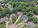 Aerial view of a residential neighborhood with well-maintained homes, lush greenery, and a pond at 102 Lake Meadow Dr, Apex, NC 27502