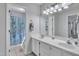 Well-lit bathroom featuring double sinks, a large mirror, and a tiled shower at 102 Lake Meadow Dr, Apex, NC 27502