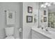 Bathroom featuring a vanity with sink, toilet, mirror, and wall decor at 102 Lake Meadow Dr, Apex, NC 27502
