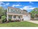 Lovely two-story house with a covered front porch, attached garage, and beautifully landscaped front yard at 102 Lake Meadow Dr, Apex, NC 27502