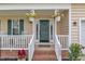Inviting front porch with hanging flower baskets, white railings, and a welcoming front door at 102 Lake Meadow Dr, Apex, NC 27502