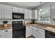 Kitchen featuring black appliances and granite countertops with white cabinets at 102 Lake Meadow Dr, Apex, NC 27502