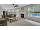 Open-concept living area with a fireplace, patio access, and views of the pool at 102 Lake Meadow Dr, Apex, NC 27502