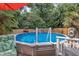 Above-ground pool with clear blue water, surrounded by lush greenery and an inviting lounge chair at 102 Lake Meadow Dr, Apex, NC 27502