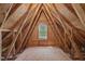 Unfinished attic space with exposed beams and window for natural light at 103 Burham Ct, Apex, NC 27502