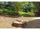 The backyard has a fire pit with stone pavers, wooden fence, and retaining wall at 103 Burham Ct, Apex, NC 27502